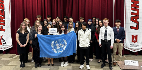 Students pose with United Nations flag at Model UN competition.