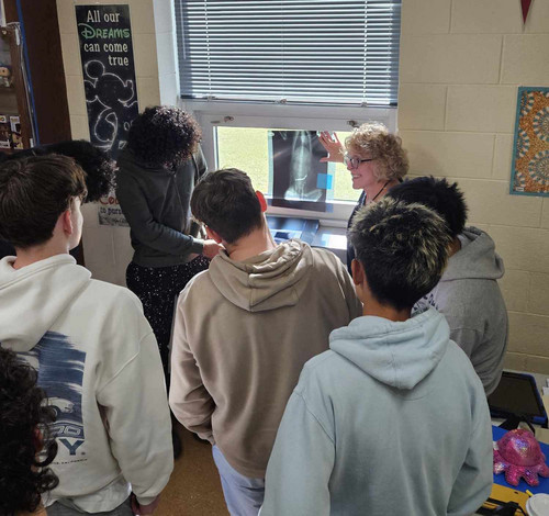 Students look at a dog xray with local veterinarian