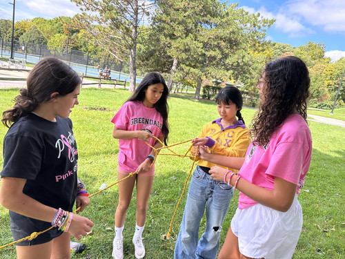 Four Girls doing ropes untangling game for team building.